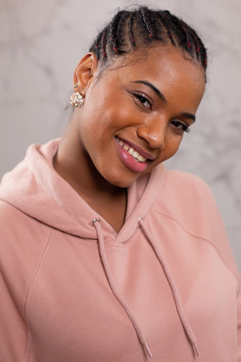 Positive black woman in pink hoodie smiling